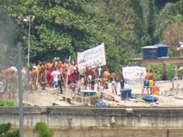 Pela manhã, presos subiram em teto de pavilhão com cartazes em protesto pacífico (Foto: Reprodução/ TV Globo)