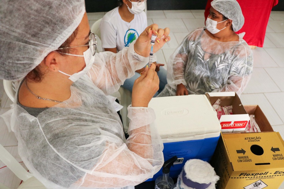 Profissionais de saúde preparam seringa para aplicação de vacina. — Foto: Ikamahã/Divulgação