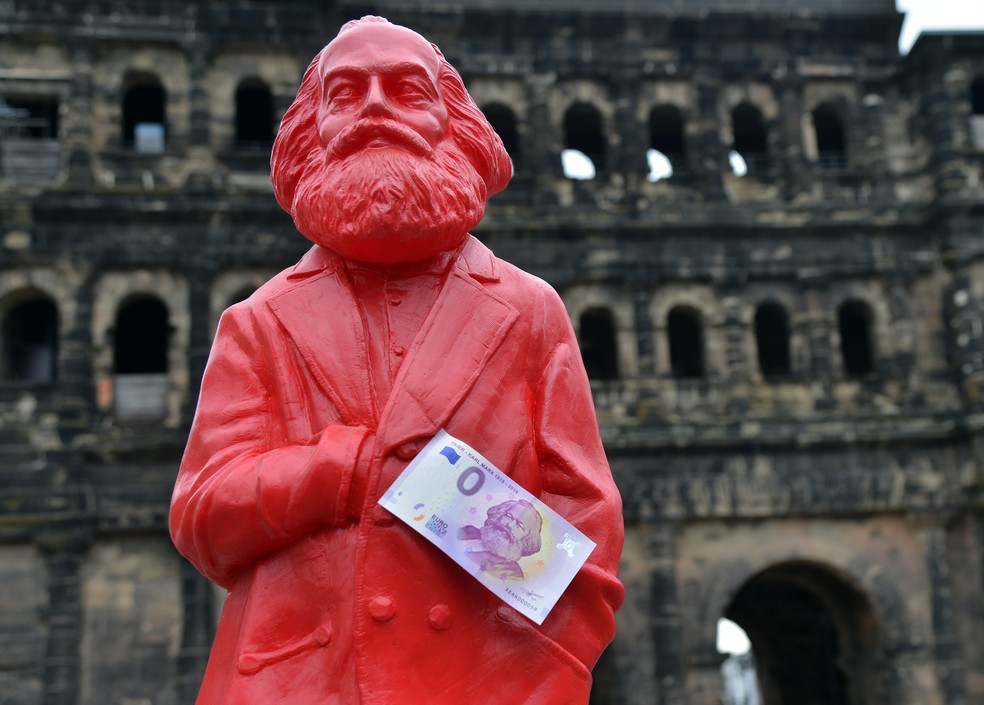 Estátua vermelha de Karl Marx com uma cédula de zero euro na cidade alemã de Trier (Foto: Harald Tittel/DPA/AFP)