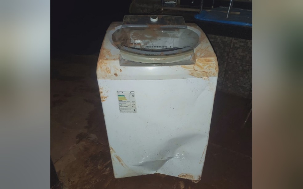 Máquina de lavar foi levada pela enxurrada e bateu no portão da casa em Anápolis, Goiás — Foto: TV Anhanguera