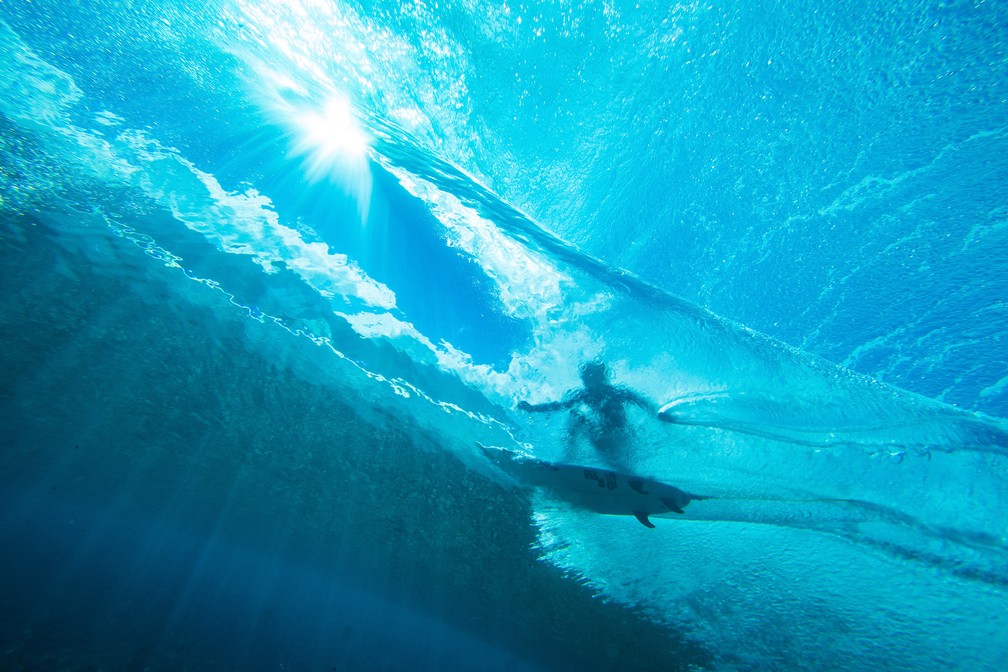 24 de agosto - A surfista brasileira Tatiana Weston-Webb é vista por baixo d'água cortando uma onda em Teahupoo, no Taiti, durante sessão do evento 2019 Tahiti Pro — Foto: Brian Bielmann/AFP