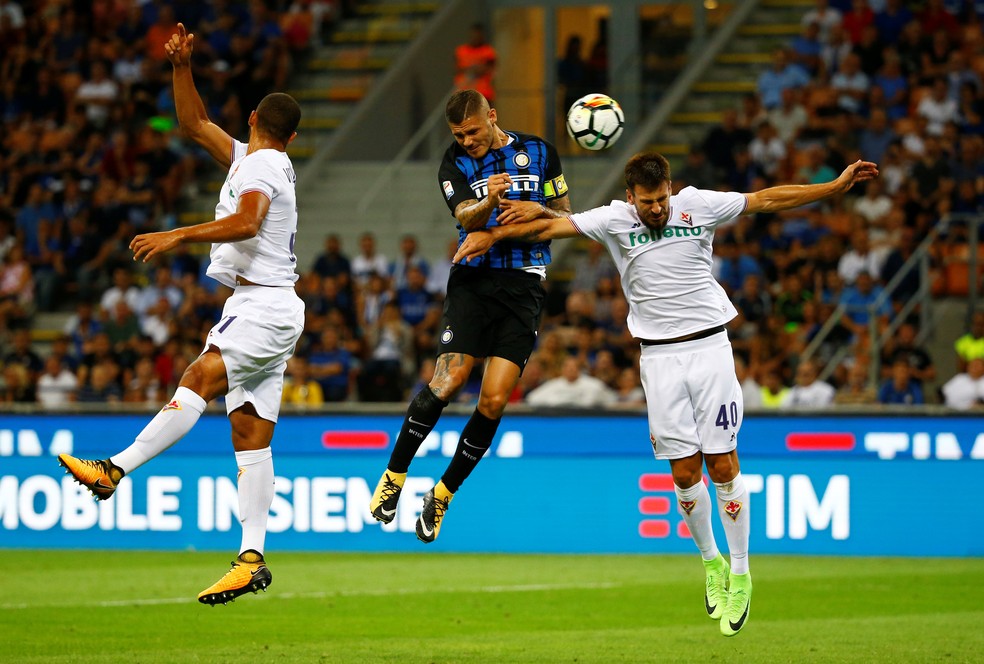 Vitor Hugo tenta tirar com a mão, mas Icardi cabeceia mesmo marcado por Tomovic em Internazionale x Fiorentina (Foto: REUTERS/Stefano Rellandini)