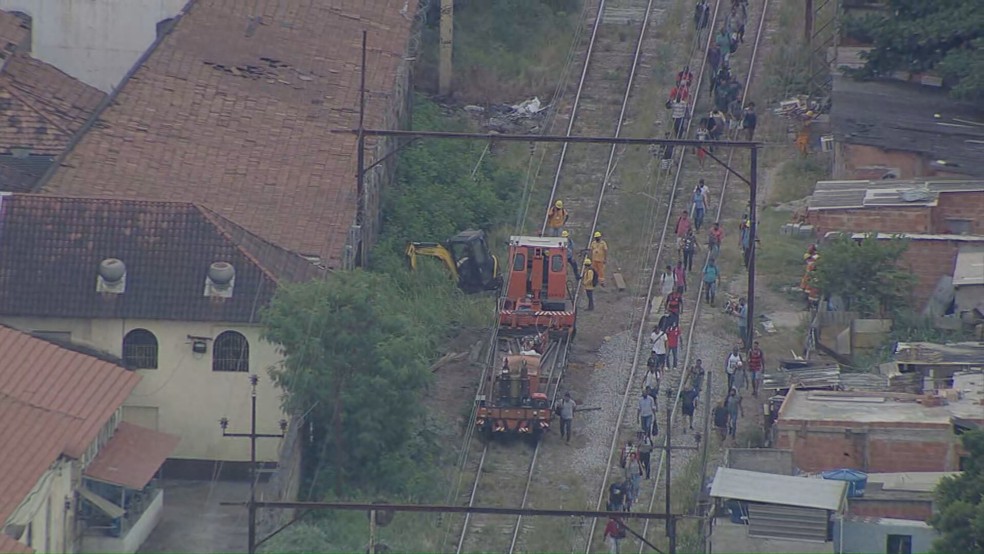 Passageiros caminham nos trilhos entre as estações Padre Miguel e Realengo da Supervia — Foto: Reprodução/ TV Globo