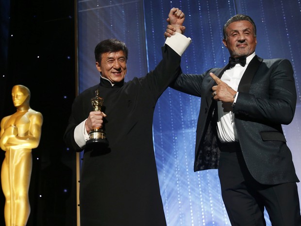 Stallone ergue o braço de Jackie Chan após a entrega do Oscar honorário ao chinês (Foto: Mario Anzuoni/Reuters)