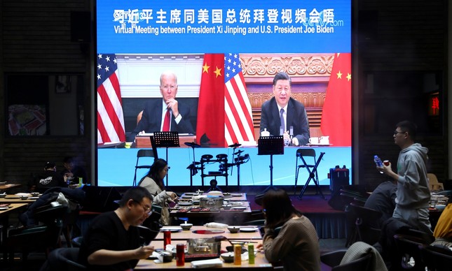 Telão em Pequim transmite imagem da cúpula virtual entre os presidentes dos EUA, Joe Biden, e da China, Xi Jinping