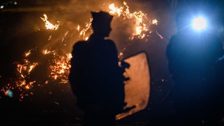 Policiais franceses protegem área após dispersão de protestos no acesso ao terminal de petróleo, no oeste da França — Foto: LOIC VENANCE/AFP