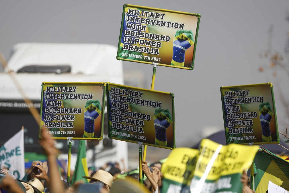 Cartazes, em inglês, pedindo intervenção militar com Bolsonaro no poder, são vistos em atos pró-Bolsonaro em Brasília — Foto: Sergio Lima/AFP
