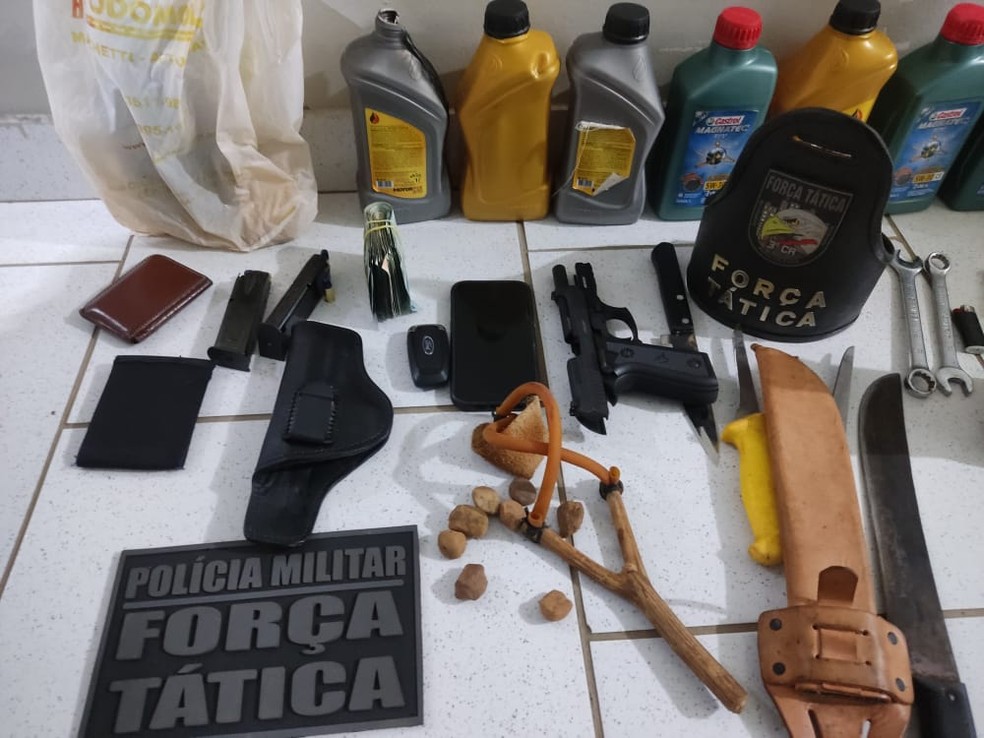 Arma e galões de combustível foram encontrados com dupla presa — Foto: Reprodução