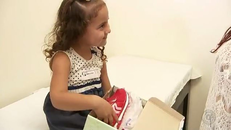 Menina de 4 anos foi rpesenteada com par de sapatos vermelho apÃ³s tratamento no pÃ© â Foto: ReproduÃ§Ã£o/TV TEM