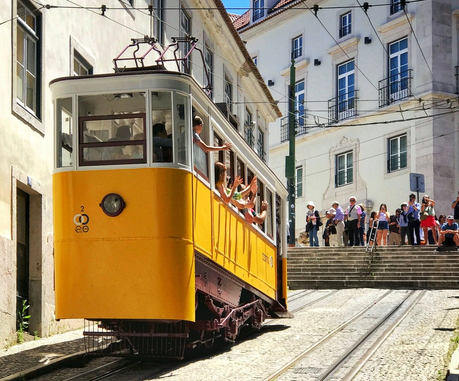 Passageiros acenam de dentro do bondinho em Lisboa