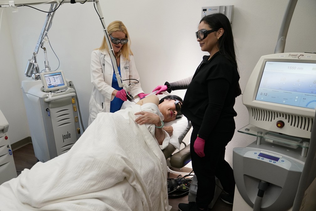 Kim Phuc recebe tratamento a laser pela Dra. Jill Waibel, à esquerda, no Miami Dermatology and Laser Institute — Foto: Lynne Sladky/AP