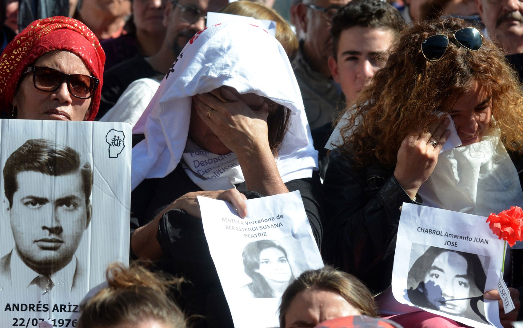Manifestantes exibem fotos de desaparecidos no lado de fora da Corte Federal de Córdoba, na Argentina, na quinta (25), durante julgamento de militares envolvidos em crimes na ditadura (Foto: Laura Lescano/TELAM AFP/AFP)