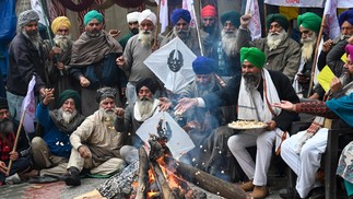 Agricultores se reúnem para celebrar o festival de Lohri enquanto protestam contra os governos central e estadual em Amritsar. — Foto: Narinder NANU / AFP