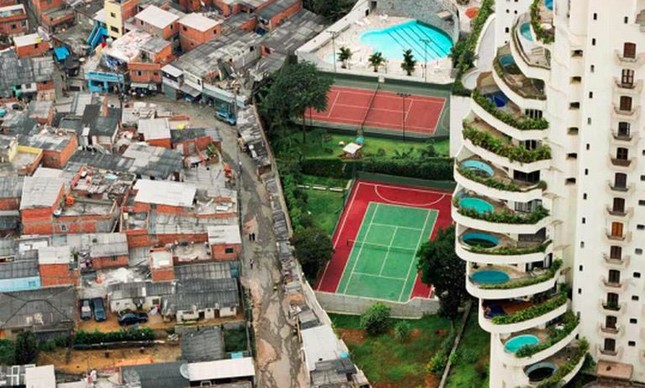 Favela ao lado de prédio com piscinas nas varandas em SP: desigualdade explícita