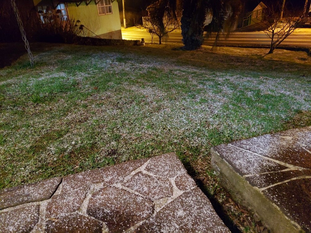 Neve acumulada na grama e calçada em São Joaquim na noite de quarta-feira (28)  Foto: Lucas Rocha/Arquivo pessoal