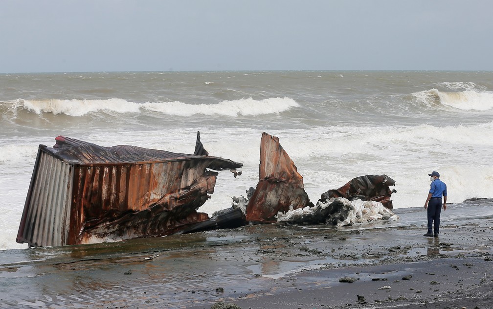 Oficial da Marinha do Sri Lanka patrulha praia perto de um contêiner danificado que caiu do navio MV X-Press Pearl, que pegou fogo por 13 dias na costa do país e causou o maior desastre ambiental da sua história, em foto de 26 de maio de 2021 — Foto: Dinuka Liyanawatte/Reuters