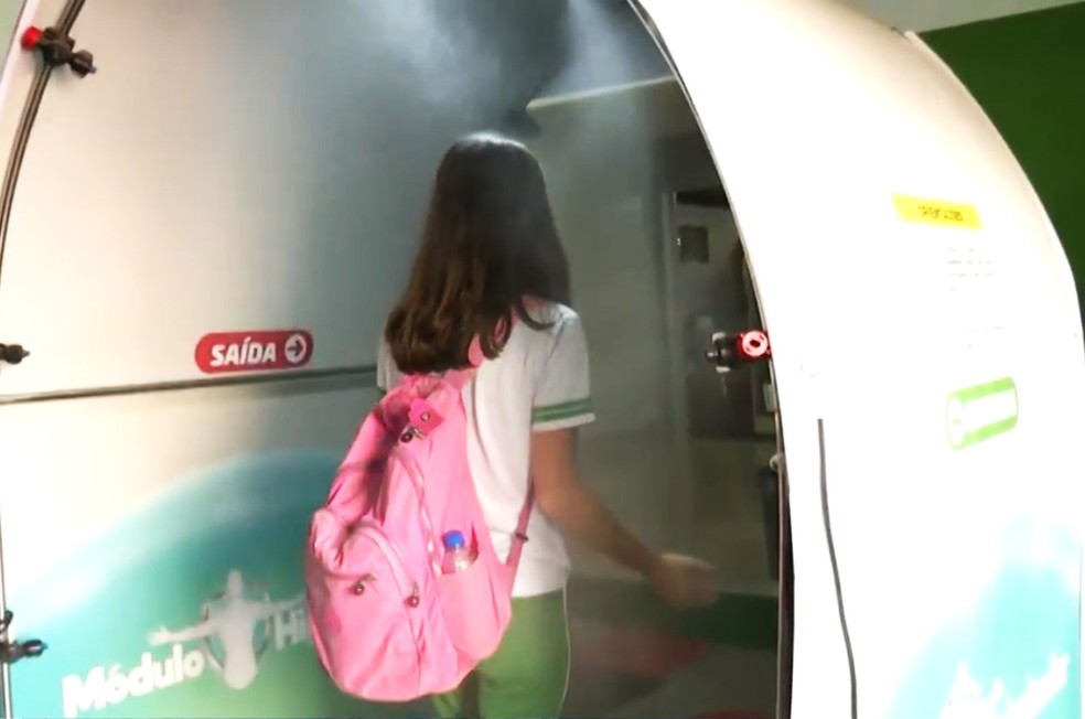 Estudante de escola particular em Luís Eduardo Magalhães passando por túnel de desinfecção instalado na unidade de ensino — Foto: Reprodução/TV Bahia