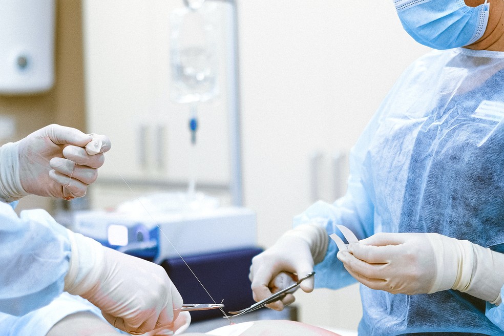 Médicos utilizando equipamentos em cirurgia plástica em centro cirúrgico — Foto: Pelxes.com