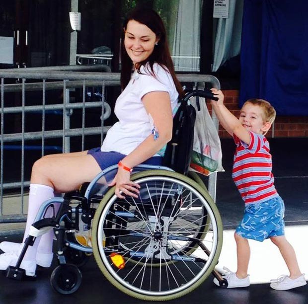 Jo Gilchrist, na cadeira de rodas, com o filho Tommy, de 7 anos: médicos disseram que talvez ela nunca volte a andar (Foto: Reprodução / Facebook Jo Gilchrist)