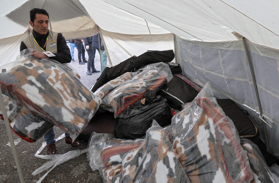 Iraquiano coleta cobertores doados em Arbil, capital da região curda autônoma do norte do Iraque, em 9 de fevereiro de 2023, para serem enviados à Turquia e à Síria após um forte terremoto que atingiu os dois países