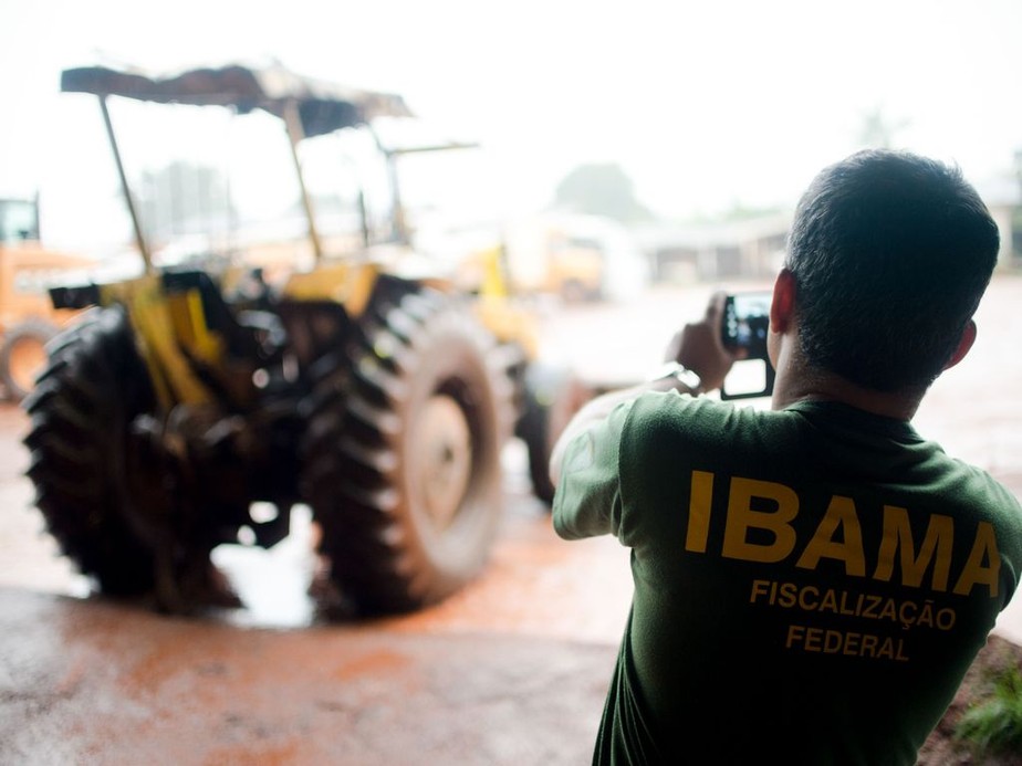 Funcionário do Ibama fotografa maquinário apreendido durante ação contra extração de madeira ilegal