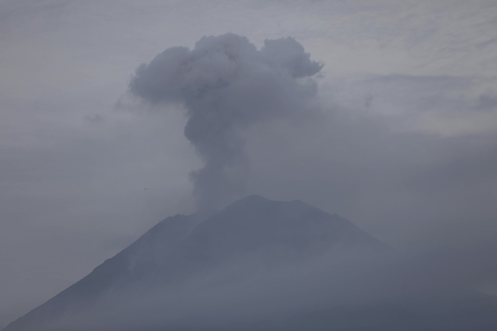 Foto mostra Monte Semeru expelindo fumaça neste domingo (5), depois de entrar em erupção no sábado (4). — Foto: Trisnadi/AP