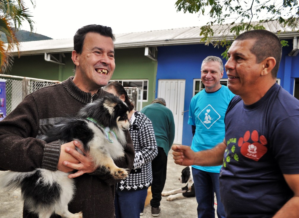 Adestrador, Eliel, e representante da empresa que leva os cães terapeutas, Jorzimar, acompanham alunos em Poços de Caldas (MG) — Foto: Camilla Resende/G1