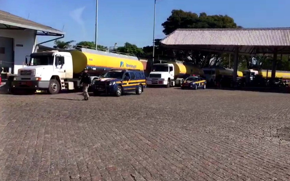 Caminhões-tanque são reabastecidos na Replan, em Paulínia, sob escolta policial (Foto: Reprodução/EPTV)