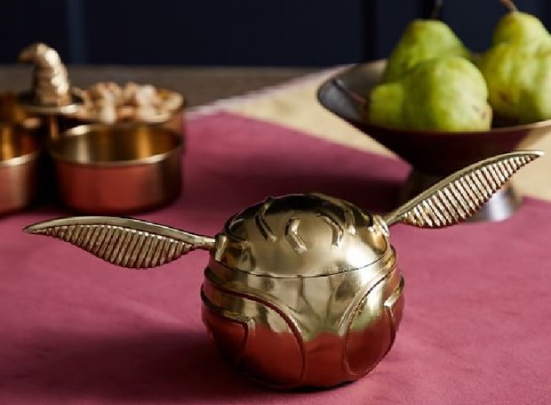 O pote dourado em formato da bola de Quadribol pode ser utilizado tanto na mesa de jantar, quanto para guardar brincos e colares, por exemplo (Foto: Pottery Barn/ Reprodução)