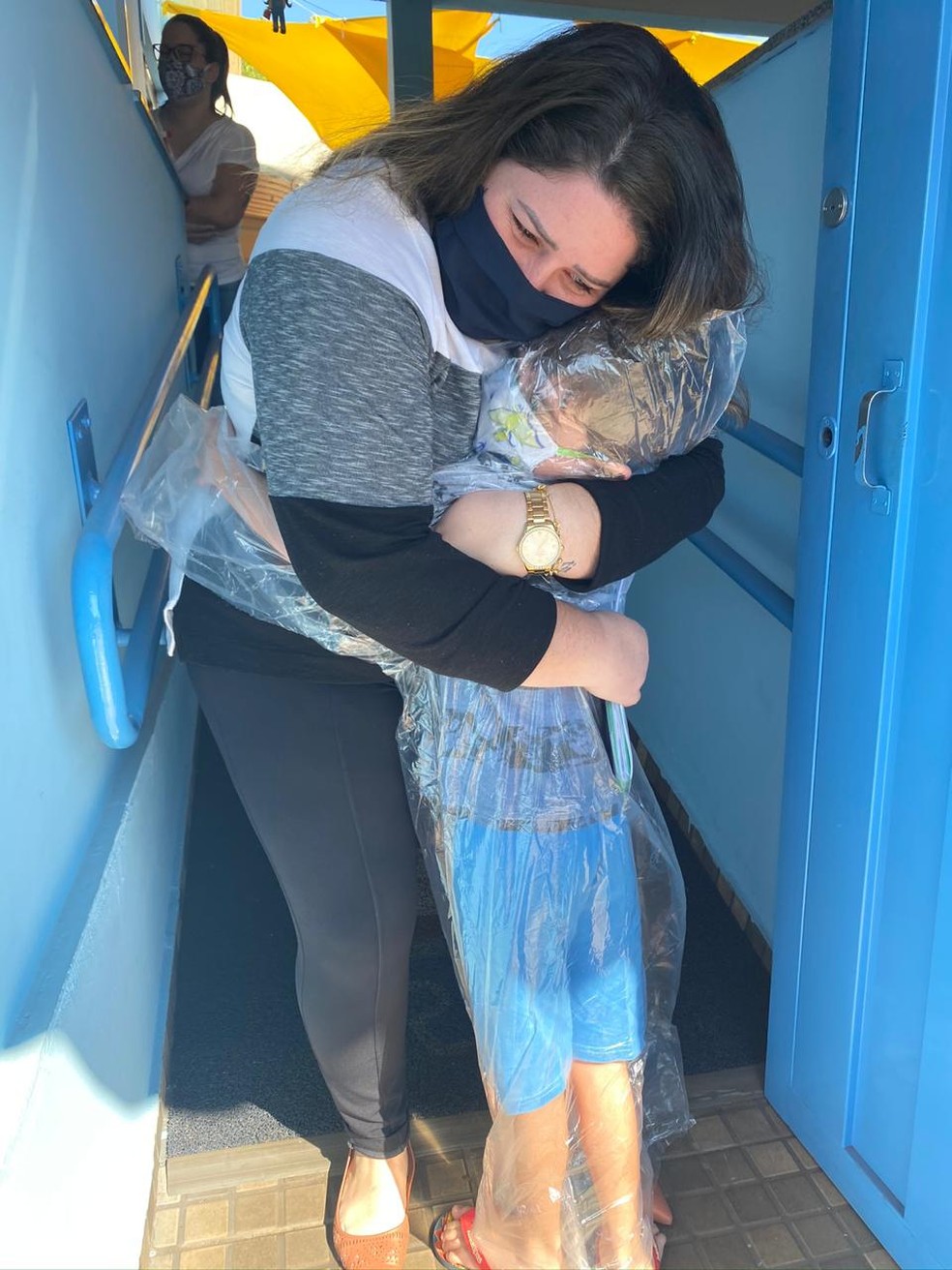 João Vicente usou uma capa de chuva para abraçar a professora em Jaú — Foto: Mariana Peres / Arquivo pessoal 