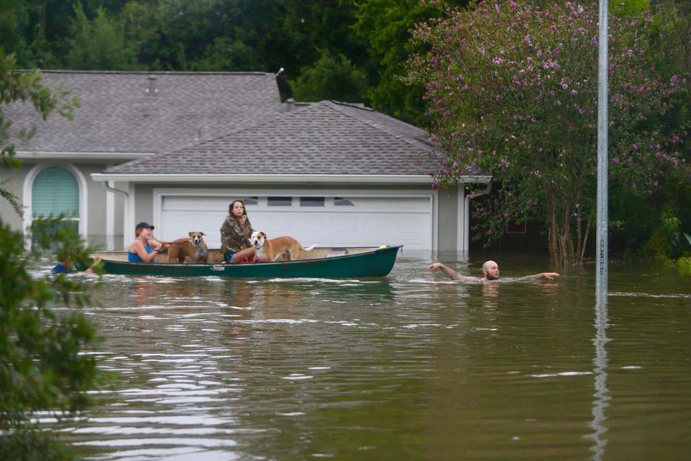 Família é resgatada em Houston neste domingo (27); moradores foram orientados a aguardar o resgate nos telhados de suas casas (Foto: Mark Mulligan/Houston Chronicle via AP)