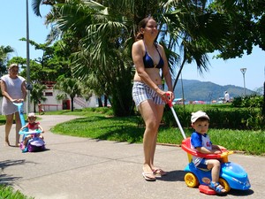 Família passeia com crianças no jardim da praia de Santos, SP (Foto: Orion Pires / G1)