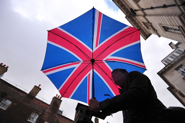 Britânico segura guarda-chuva com estampa da bandeira do Reino Unido (Foto: Carl Court/AFP/Getty Images)