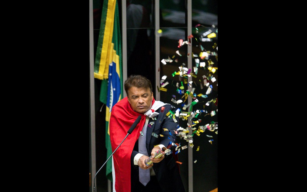 O deputado Wladimir Costa (Solidariedade/PA) solta confetes durante sessão que discute o processo de impeachment da presidente Dilma Rousseff no plenário da Câmara, em Brasília (Foto: Daniel Teixeira/Estadão Conteúdo)