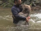 Homem se arrisca e é filmado brincando com urso em rio 