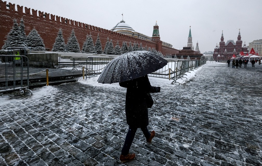 Mulher caminha durante nevasca em frente ao Kremlin, sede do governo russo na Praça Vermelha, em Moscou — Foto: Yuri Kadobnov/AFP