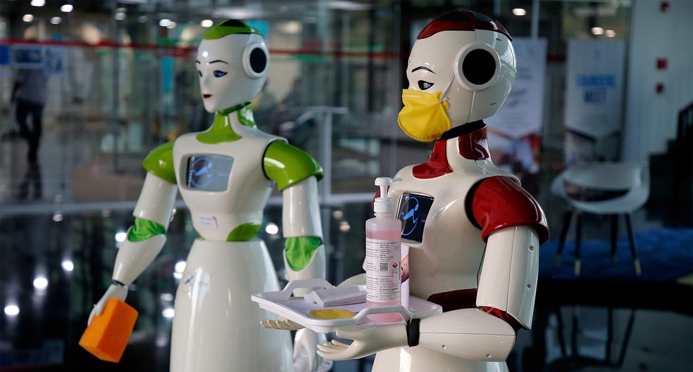Robôs com máscara e produtos de higiene são usados para conscientização sobre o novo coronavírus em Kochi, na Índia. Lançados pela start-up Asimov Robotics, os robôs distribuem materiais de proteção, higienizam superfícies e exibem informações sobre a campanha da Organização Mundial da Saúde (OMS) para prevenção da Covid-19 — Foto: Sivaram V / Reuters