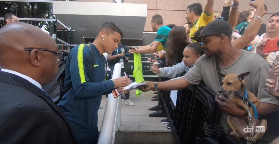 Thiago Silva assinando carteira de trabalho de fã ao embarcar para Arena Corinthians (Foto: Reprodução YouTube)