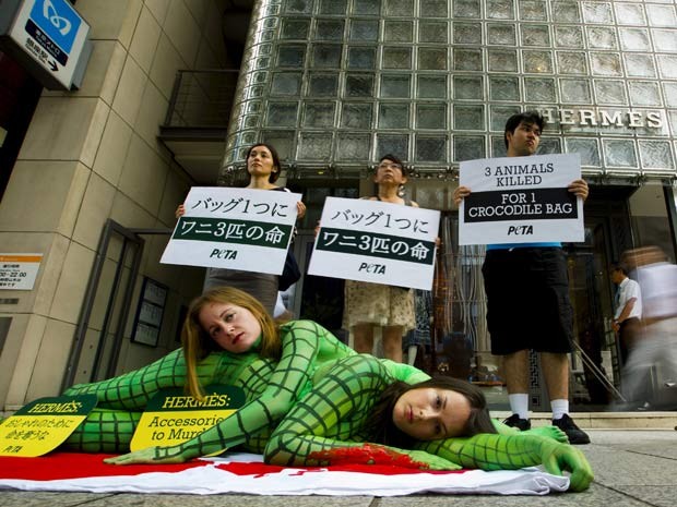 Ativistas do PETA protestam nesta quinta-feira (30) em frente à loja da Hermes em Tóquio contra o uso de pele de crocodilo em bolsas da marca (Foto: REUTERS/Thomas Peter)