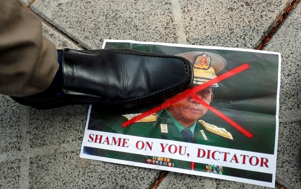 Pessoa pisa em foto do general Min Aung Hlaing, responsável pelo golpe militar em Mianmar, durante protesto do lado de fora de prédio da ONU em Bangcoc, na Tailândia, na terça-feira (2) — Foto: Reuters/Jorge Silva 