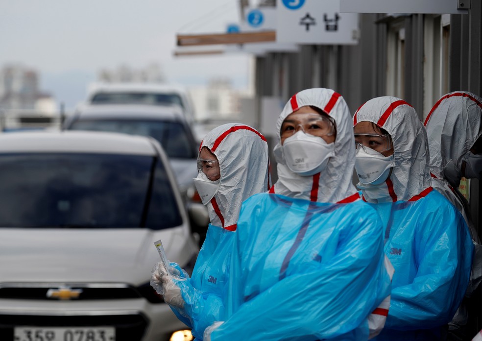Coreia do Sul - Equipe médica usa trajes de proteção em 'drive-thru' de centro montado para realizar testes de coronavírus no Centro Médico da Universidade Yeungnam, em Daegu — Foto: Reuters/Kim Kyung-Hoon/File Photo