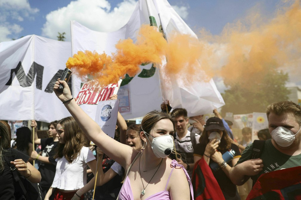 Greve pelo Clima em Londres, na Inglaterra: manifestante empunha um sinalizador durante protesto nesta sexta (24). — Foto: Aaron Chown/PA via AP