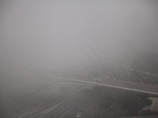 Veículos surgem do meio da neblina que à distância 'escondeu' boa parte da Ponte Estaiada Octávio Frias de Oliveira, na Zona Sul de São Paulo. A capital paulista amanheceu com tempo frio e neblina em algumas regiões na primeira sexta-feira do inverno (Foto: Fábio Tito/G1)