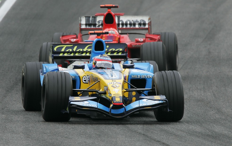 Fernando Alonso segura a pressão de Michael Schumacher nas voltas finais em San Marino-2005 — Foto: Clive Mason/Getty Images