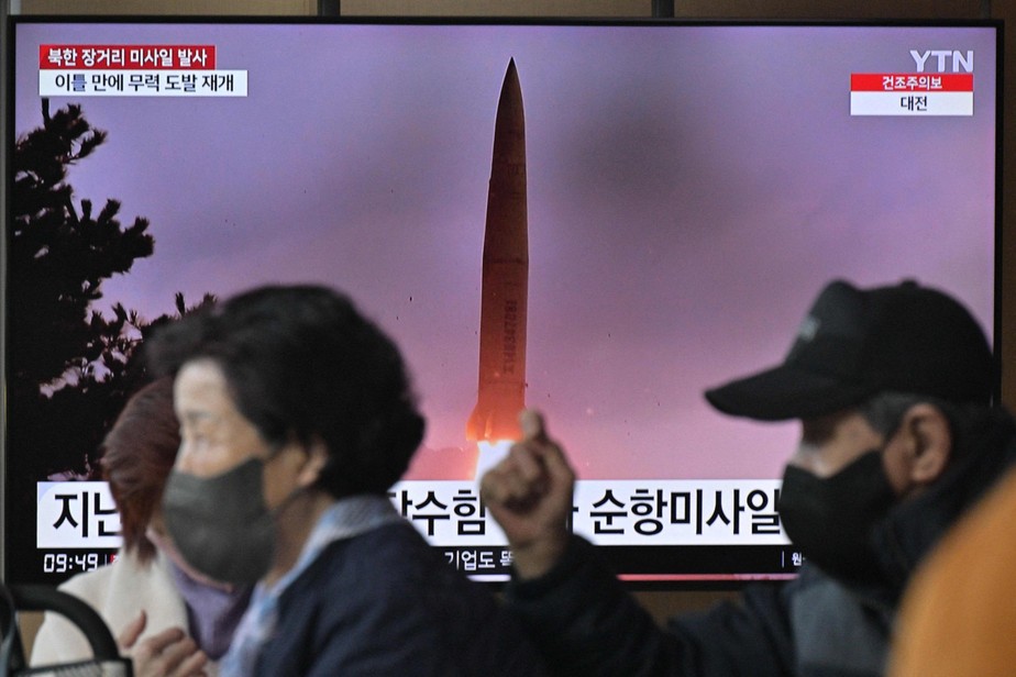 Sul-coreanos caminham em frente à televisão que mostra lançamento de míssil pela Coreia do Norte
