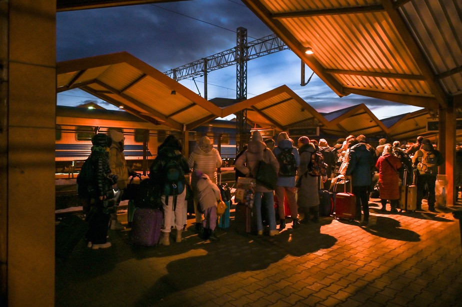 Ucranianos fazem fila para o controle de passaportes na fronteira com a Polônia na estação ferroviária de Przemysl