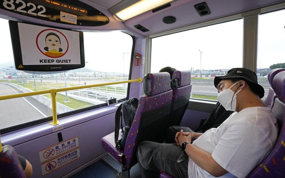 Passageiro dorme na parte superior de ônibus de dois andares durante tour por Hong Kong, no sábado (16) — Foto: AP Photo/Kin Cheung