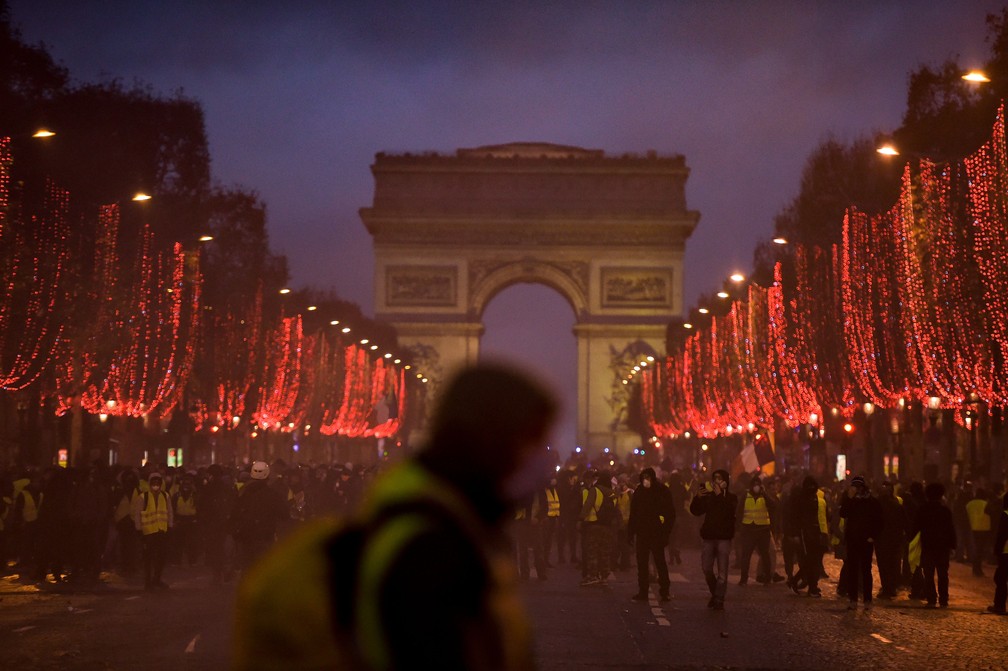 Manifestantes se reúnem na Champs-Elysées, perto do Arco do Triunfo, em Paris — Foto: Lucas Barioulet / AFP