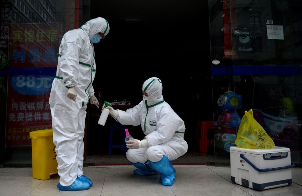 Funcionário da saúde desinfecta colega em clínica de testagem para a Covid-19 — Foto: Noel Celis/AFP