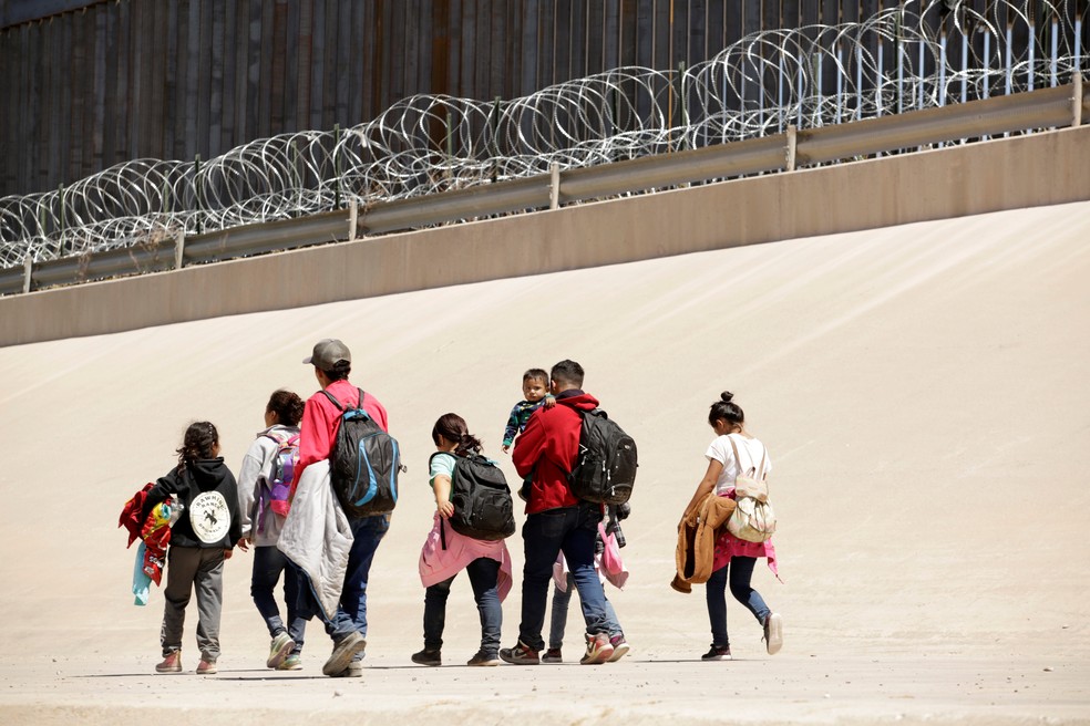 Migrantes caminham na linha de fronteira entre Ciudad Juárez, no México, e El Paso, no Texas, no dia 9 de maio. — Foto: Jose Luis Gonzalez/Reuters